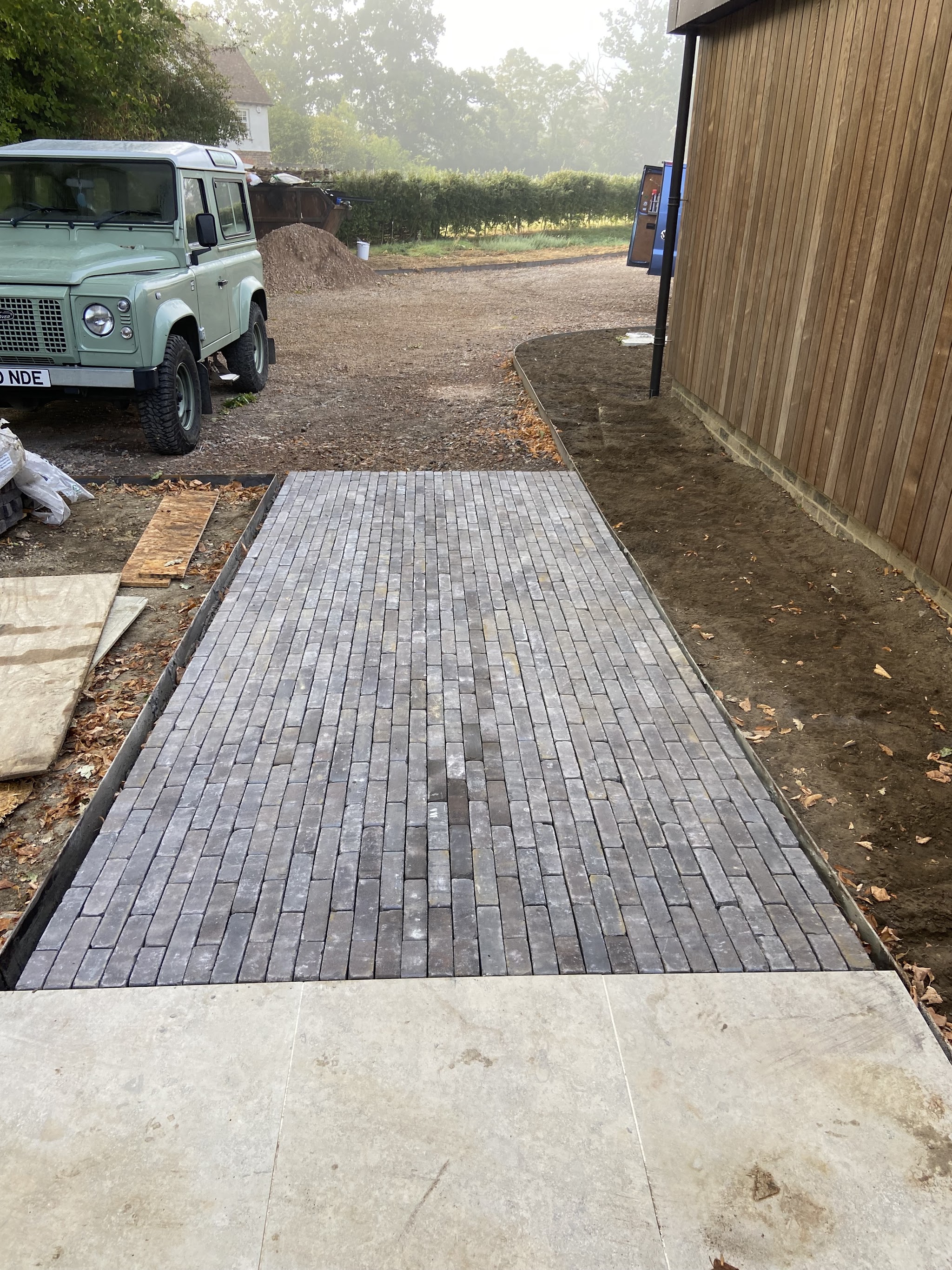 Freshly laid strip of dark block paving on a rural drive