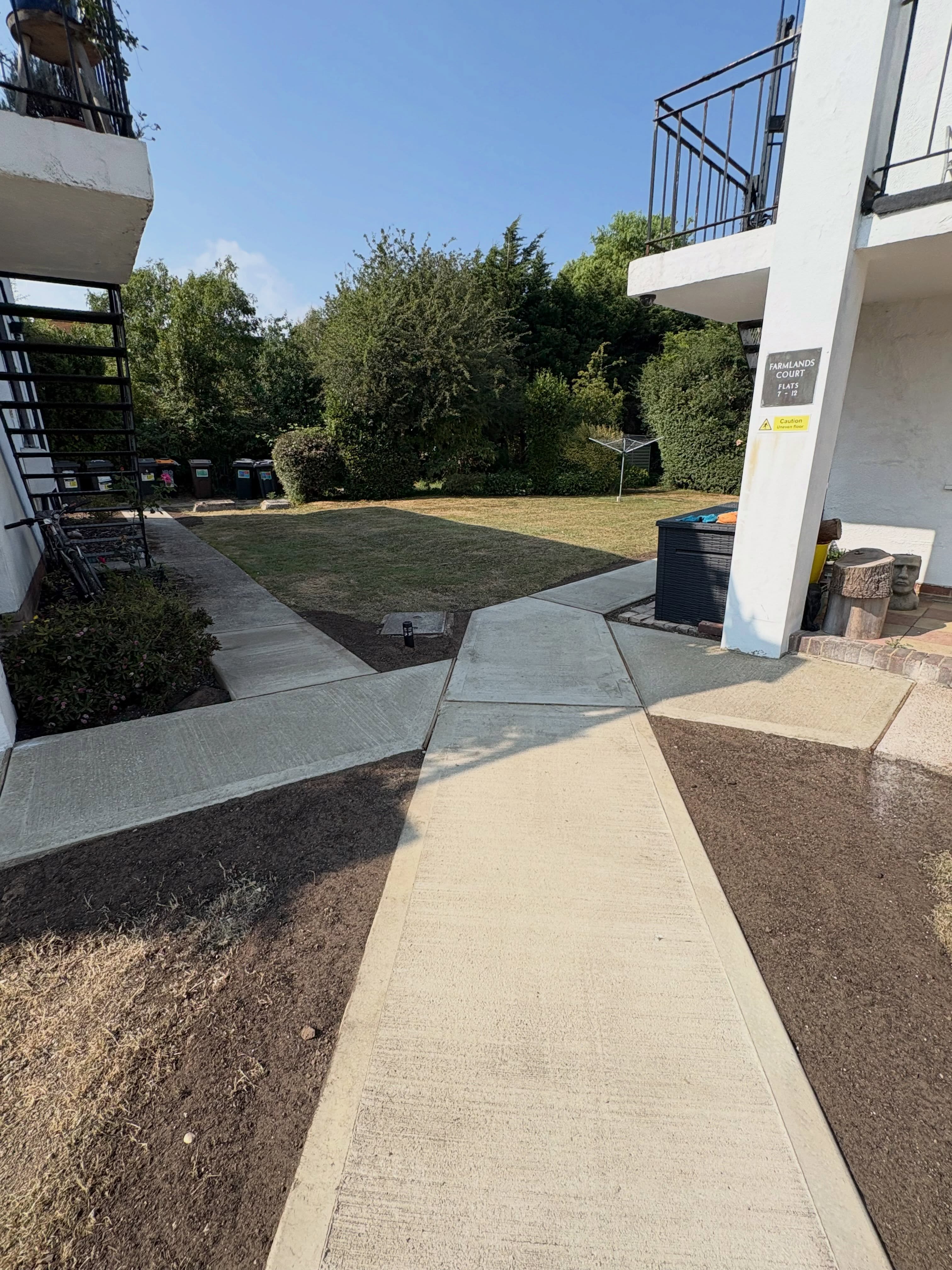 New path through a freshly prepared lawn beside a block of flats